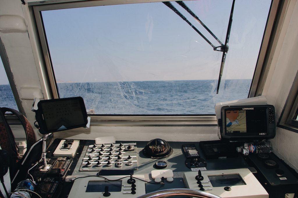 Uma imagem do interior de um barco, mostrando os assentos, o leme e outros elementos da embarcação.
