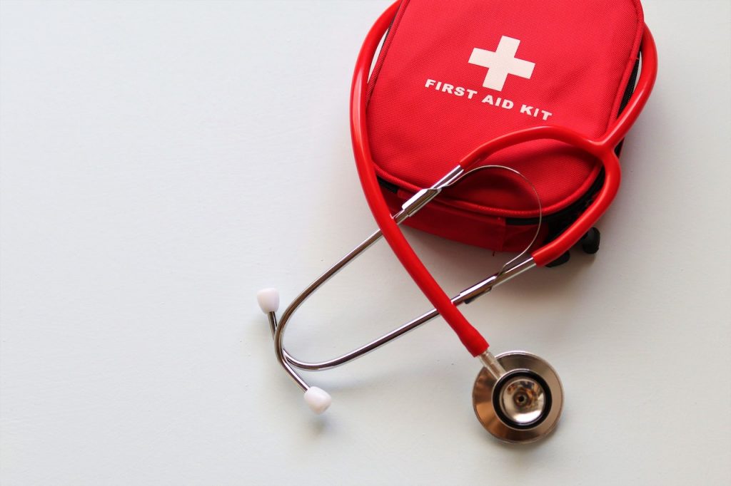 Uma imagem de uma caixa de primeiros socorros vermelha, contendo suprimentos médicos e de emergência.